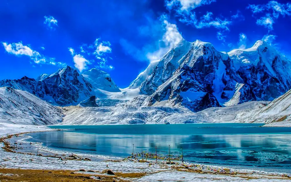 Gurudongmar Lake in North Sikkim with turquoise water and snow-covered peaks, a highlight of Sikkim package tours.